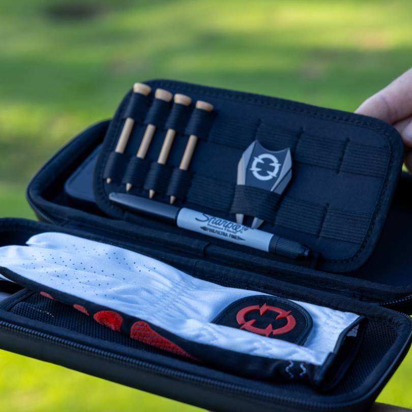 EXO Golf glove case open showing EXO Golf Glove red colorway stored alongside tees ball marker and Sharpie in organized compartments
