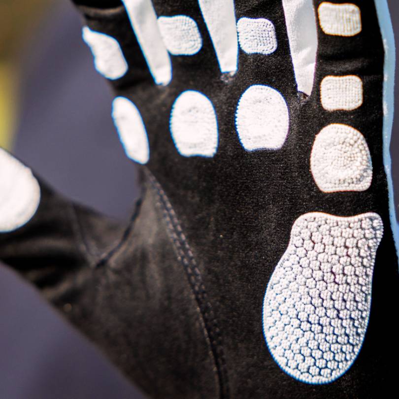 EXO Golf Glove white colorway close up showing Zyntech™ nanocell grip pad layout across palm on black background