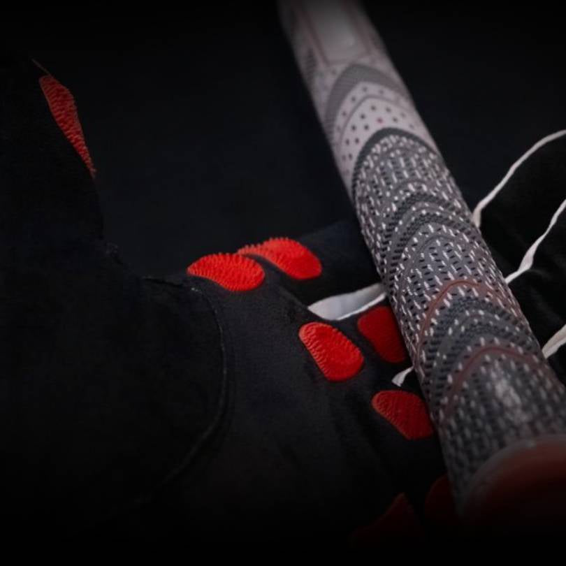 EXO Golf Glove red colorway close up showing Zyntech nanocell grip pads making contact with golf club grip