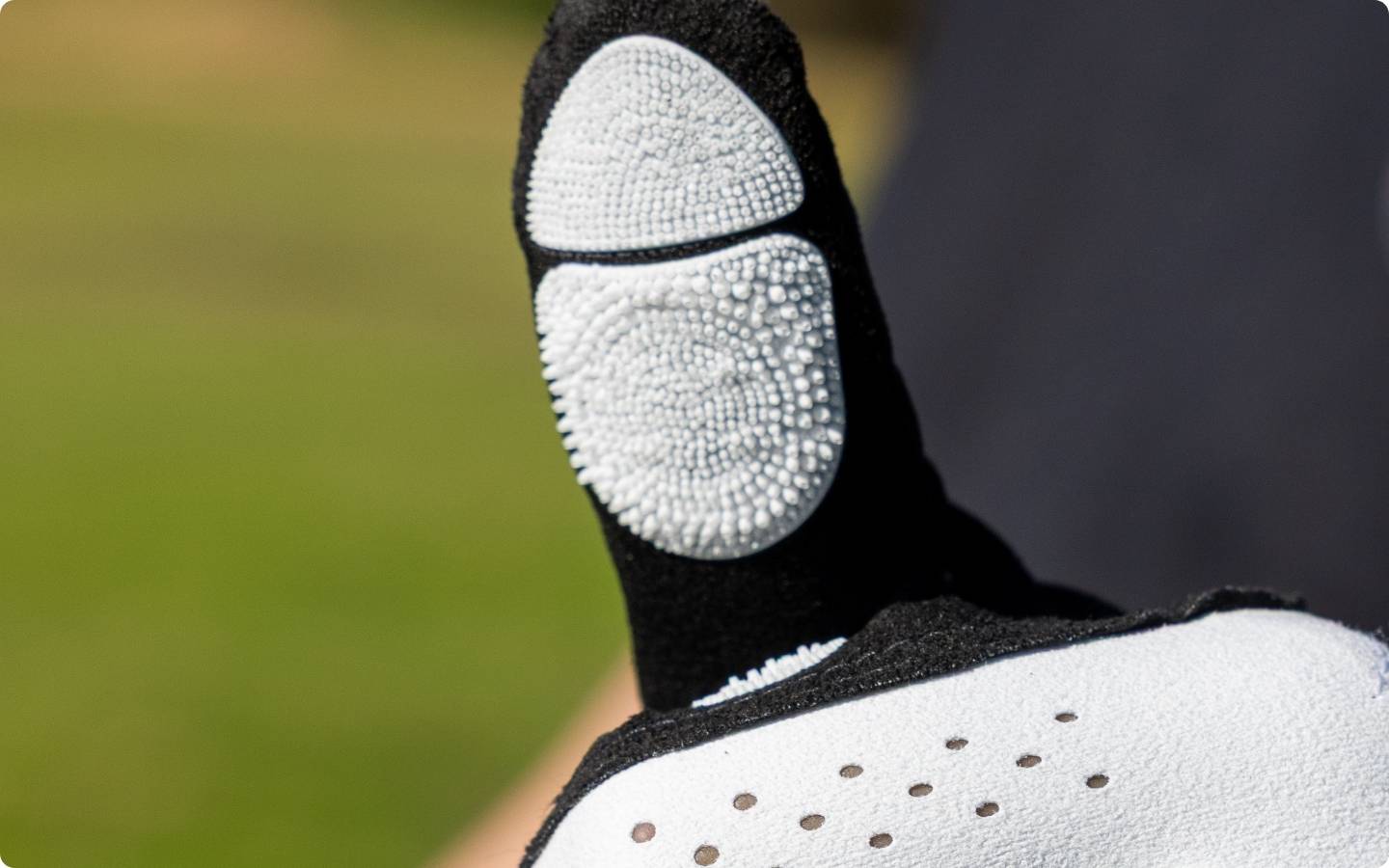 EXO Golf Glove white colorway extreme close up showing Zyntech nanocell texture on thumb grip pad