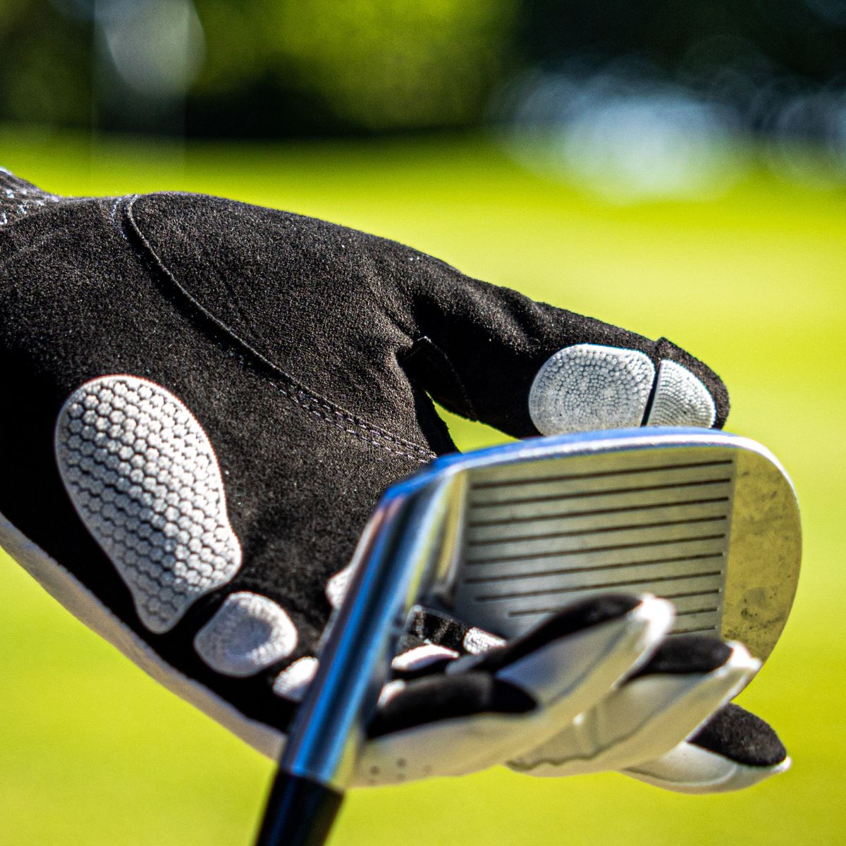 EXO golf glove with white nanocells holding the head of a golf club