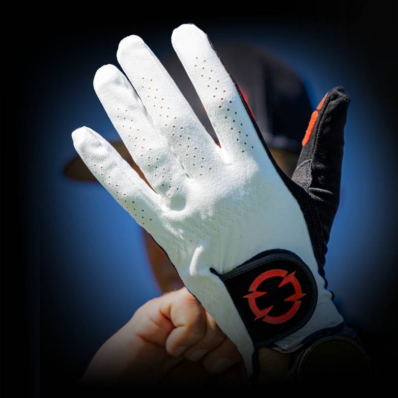 Golfer putting on EXO Golf Glove red colorway showing perforated back of hand panel and EXO logo on wrist strap